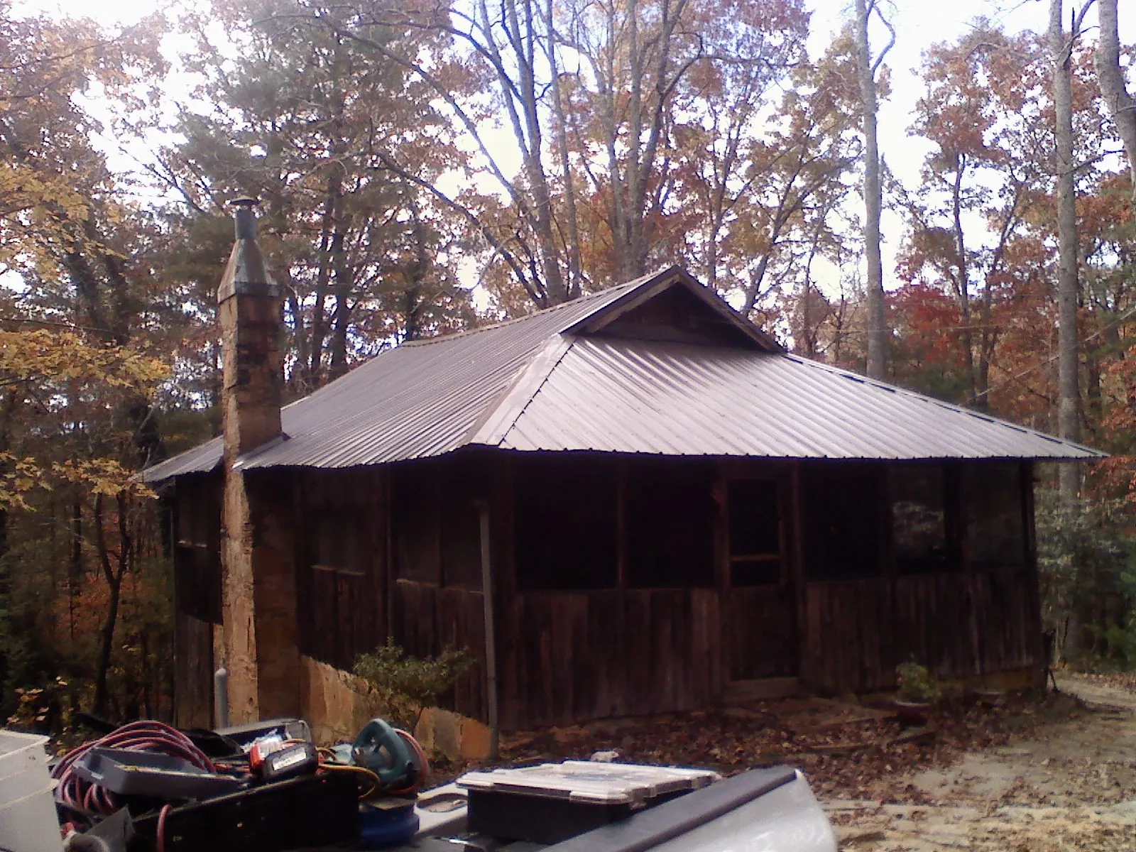 Brown metal hip roof on an old cabin with a stone chimney in Rainier